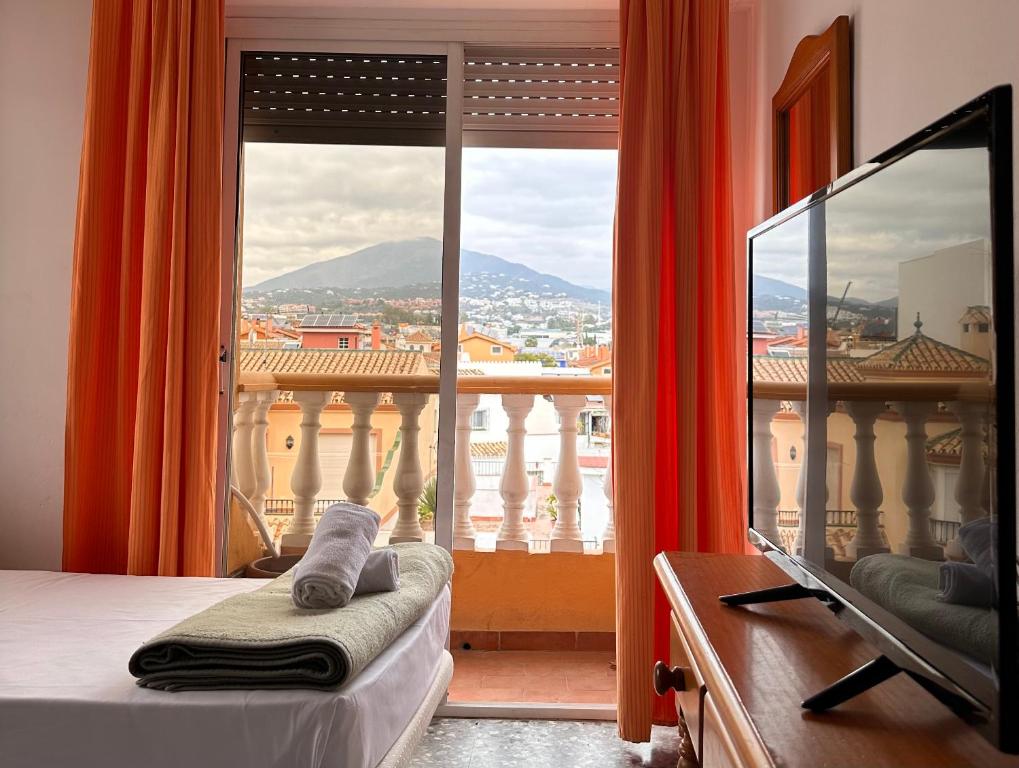 a bedroom with a large window with a view at Hostal San Felipe in Marbella