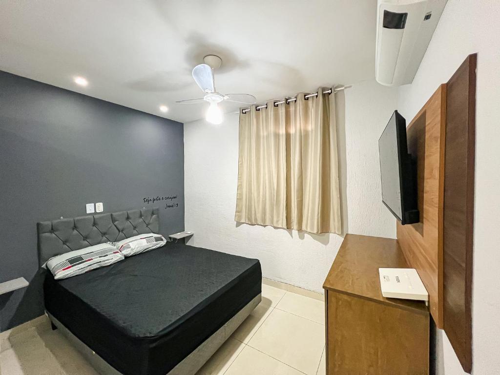 een slaapkamer met een bed en een flatscreen-tv bij Kitnet Charmosa Cabo Frio in Cabo Frio