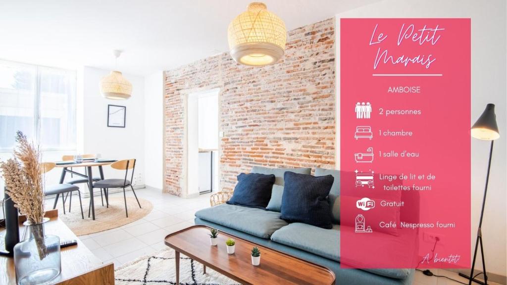 a living room with a couch and a brick wall at Le Petit Marais in Amboise