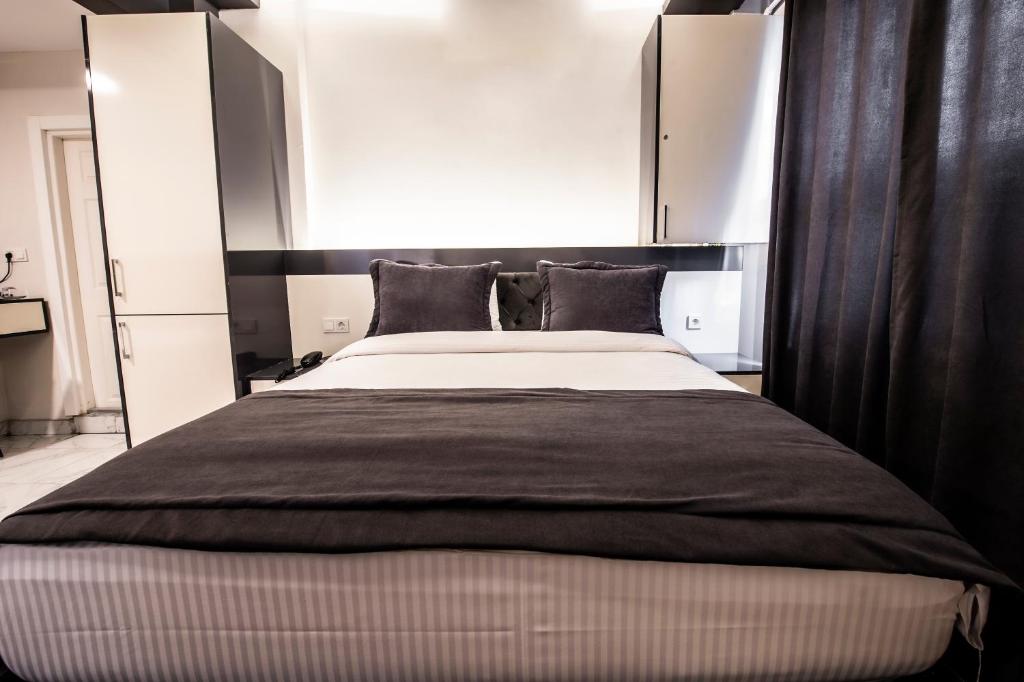 a bedroom with a large bed with a black headboard at Bakırköy Zeugma Suit Otel in Istanbul