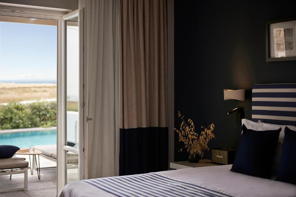a bedroom with a bed and a view of a pool at Summer Senses Luxury Resort in Logaras