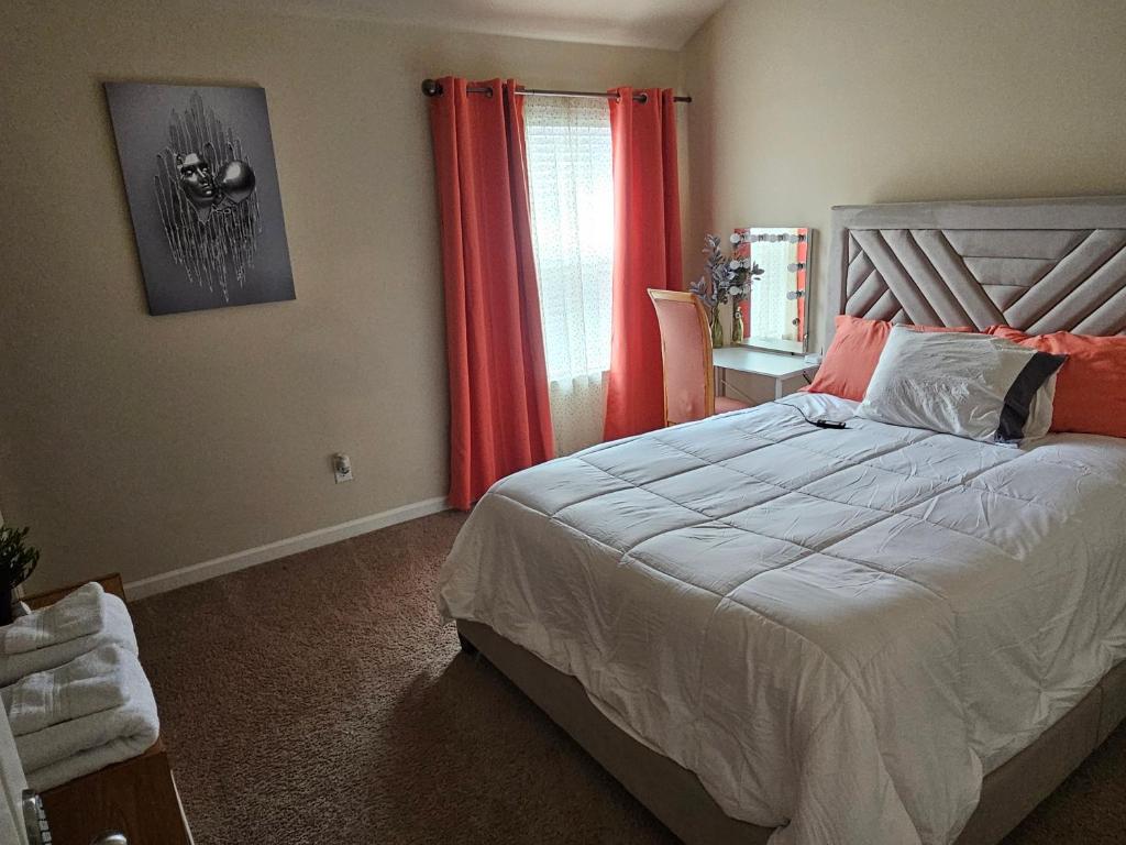 a bedroom with a bed and a window with red curtains at Elizabeth Experiences in Atlanta