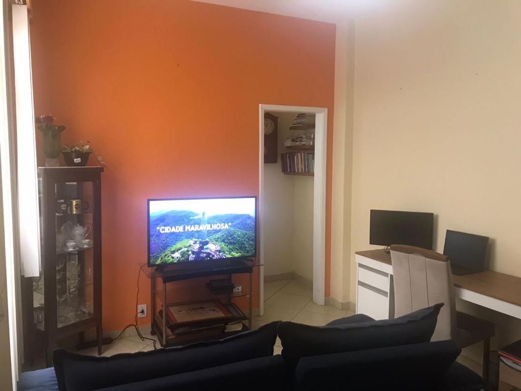 uma sala de estar com um sofá e uma televisão de ecrã plano em Apto Olaria no Rio de Janeiro