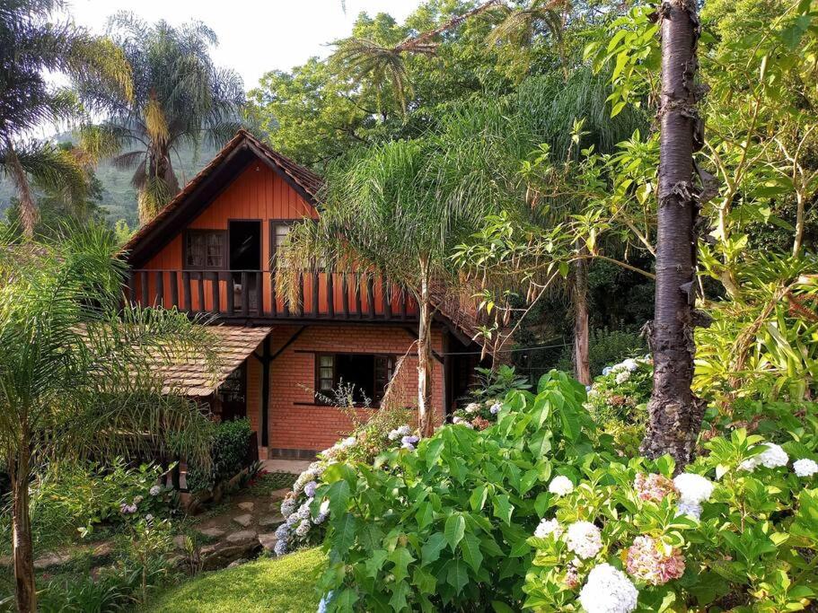 Morro Azul Chalés في تيمبو: منزل صغير وسط حديقة