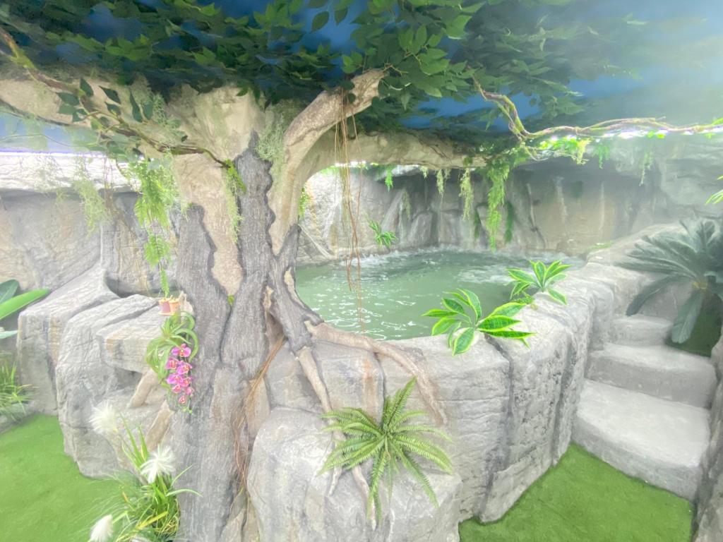 a garden with a tree and a pond at Futurotel Room Spa Garden in Granada