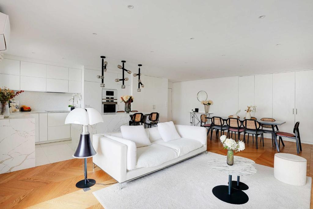 Sala de estar blanca con sofá blanco y mesa en Modern spacious apartment just outside Paris, en Levallois-Perret