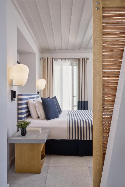 a bedroom with a king sized bed and a table at Summer Senses Luxury Resort in Logaras