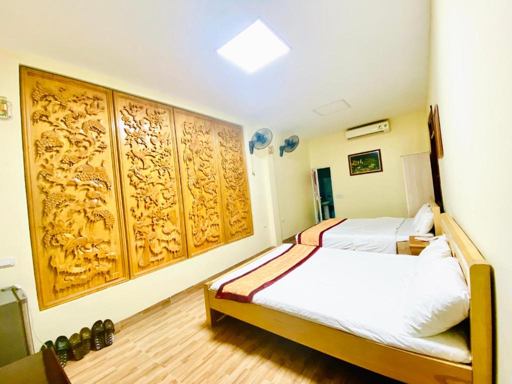 a bedroom with two beds and wooden panels at HOTEL HOÀNG LONG in Diện Biên Phủ