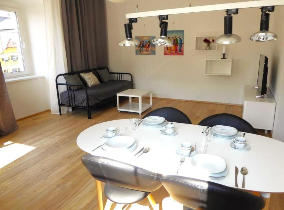 - une table et des chaises blanches dans le salon dans l'établissement Altstadtwohnung Traunstein mit Traunseeblick 1A, à Gmunden