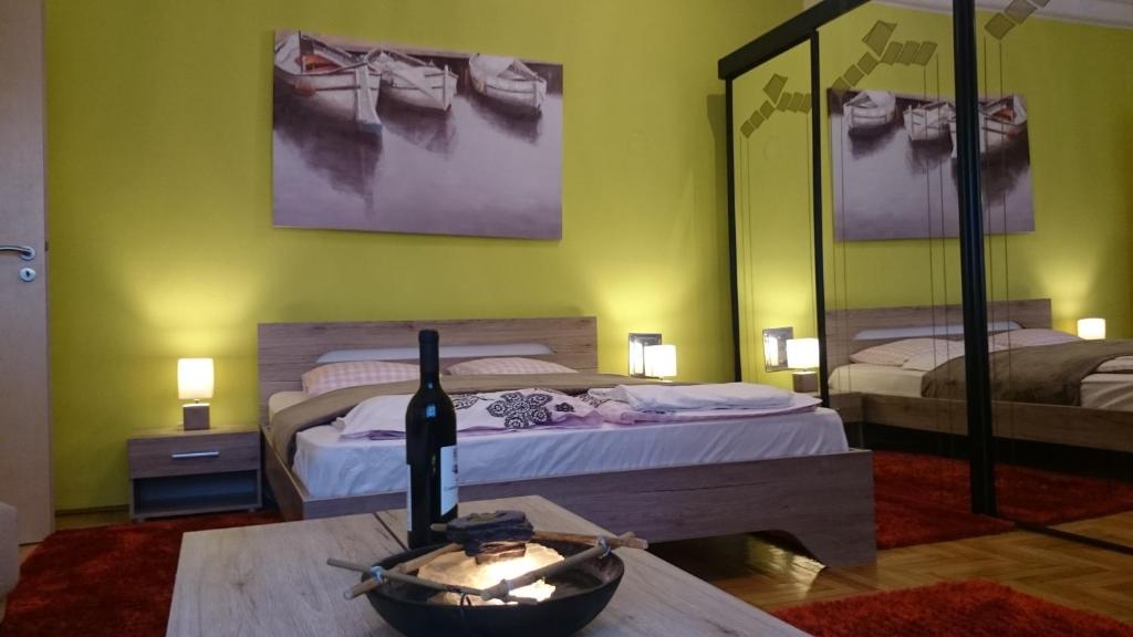 ブダペストにあるDélibáb Apartmentのベッド2台、ワイン1本(テーブル上)が備わる客室です。