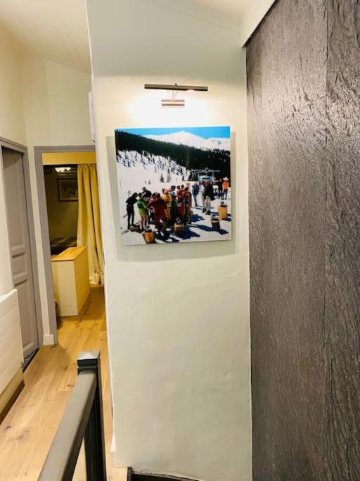 a hallway with a picture on a wall at Family cocoon Prime Rochebrune location in Megève