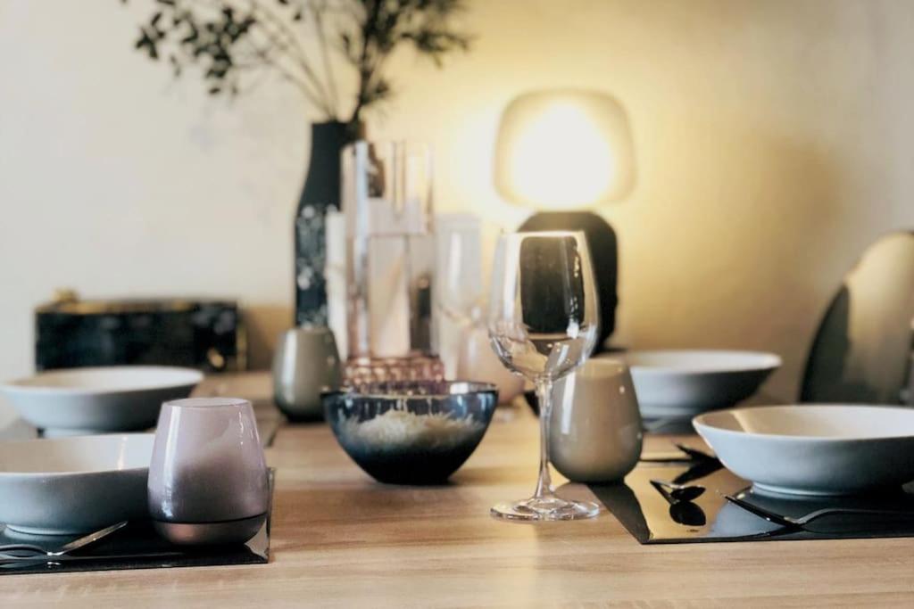 a wooden table with bowls and wine glasses on it at Family cocoon Prime Rochebrune location in Megève