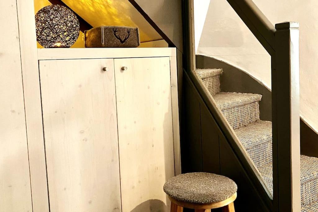 a wooden cabinet with a stool next to a staircase at Family cocoon Prime Rochebrune location in Megève