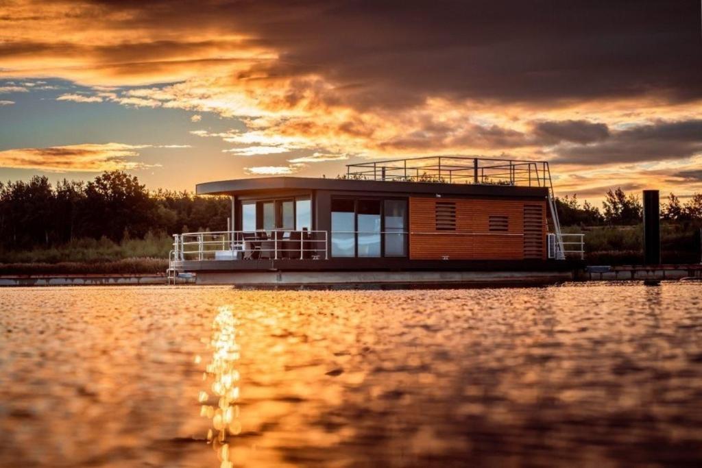 una pequeña casa en un barco en un lago en Hausboot Skyline en Klitten