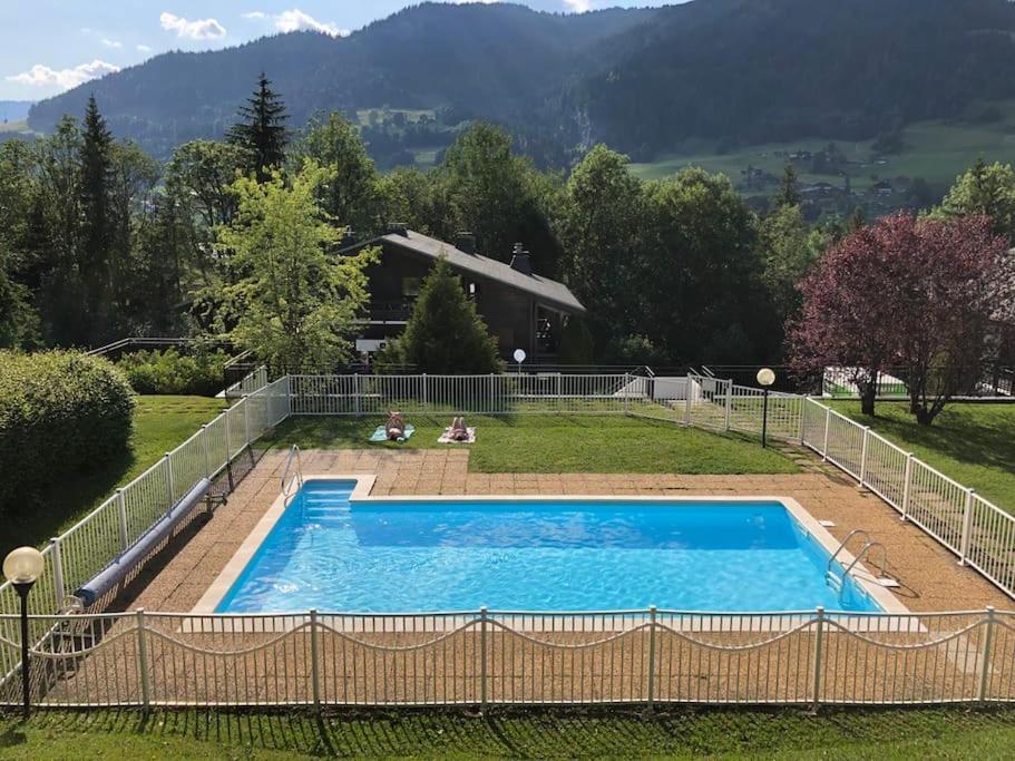 a swimming pool in the yard of a house at Family cocoon Prime Rochebrune location in Megève