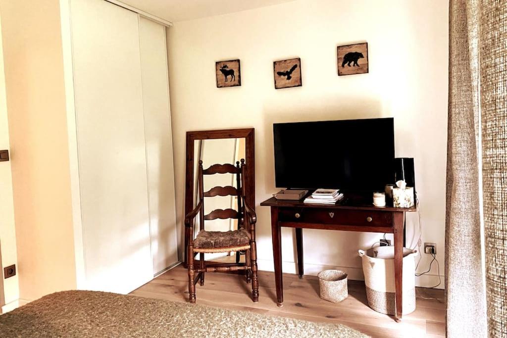 a room with a desk with a television and a chair at Family cocoon Prime Rochebrune location in Megève