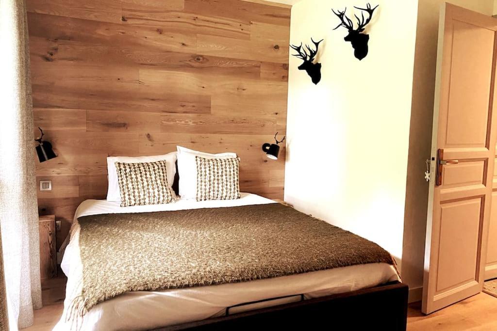 a bedroom with a bed with a wooden wall at Family cocoon Prime Rochebrune location in Megève