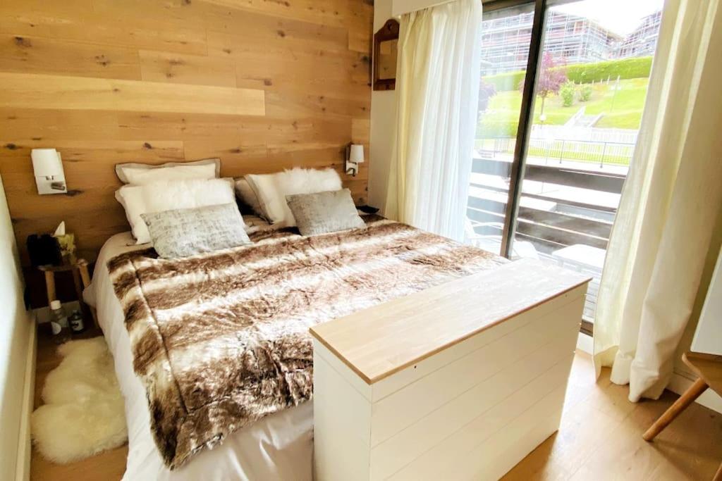 a bedroom with a bed and a large window at Family cocoon Prime Rochebrune location in Megève