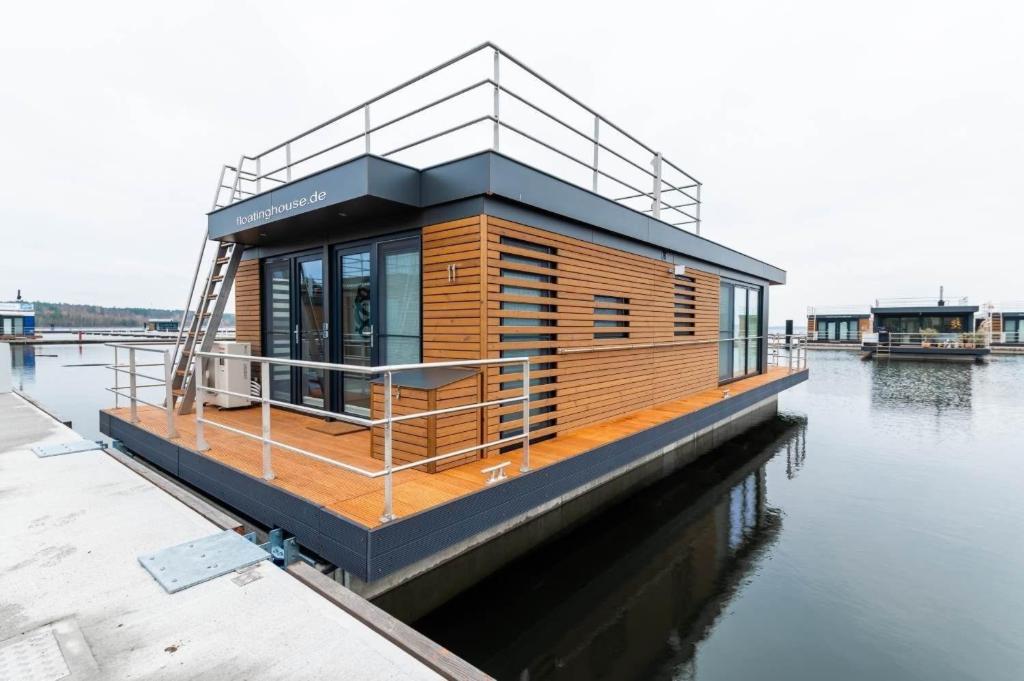 a tiny house on a dock on the water at Hausboot Atlantis in Klitten