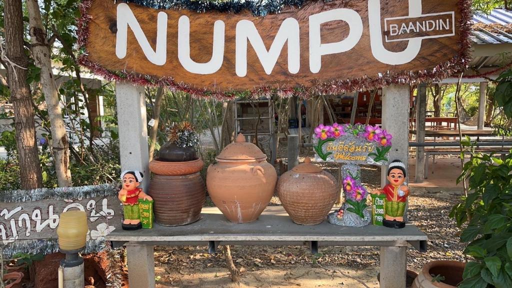 ein Tisch mit ein paar Vasen darüber in der Unterkunft Numpu Baandin in Sam Roi Yot