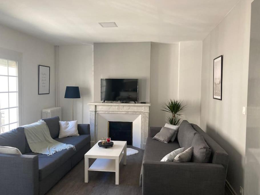 un salon avec un canapé et une cheminée dans l'établissement La chambre du coliving proche gare, à Agen