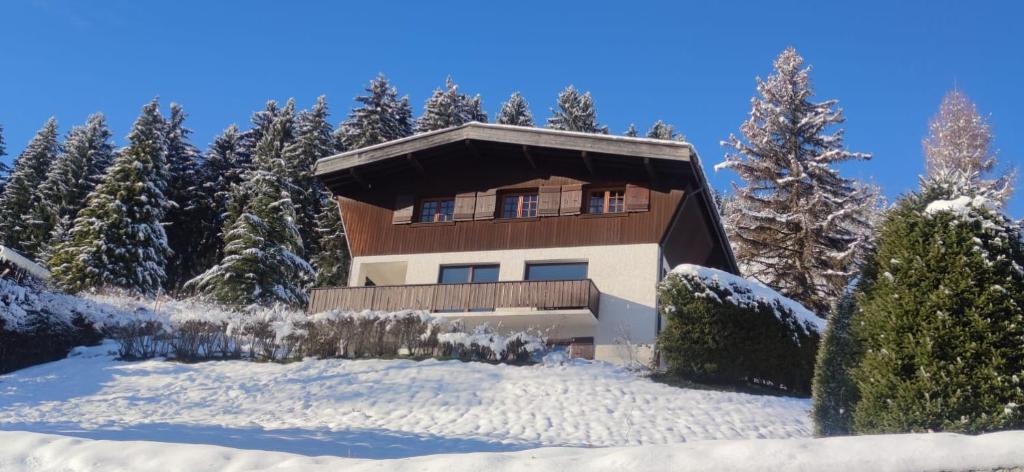 a house on a snow covered hill with trees at Chalet familial à Megève, vue sur le village in Megève