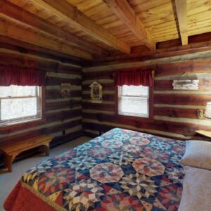 een slaapkamer met een groot bed in een hut bij Shawnee in Logan