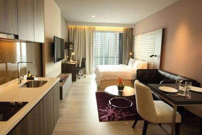 um quarto de hotel com uma cama, uma cozinha e uma sala de estar em 1ceylon luxury pharoah apartment 2310 em Kuala Lumpur