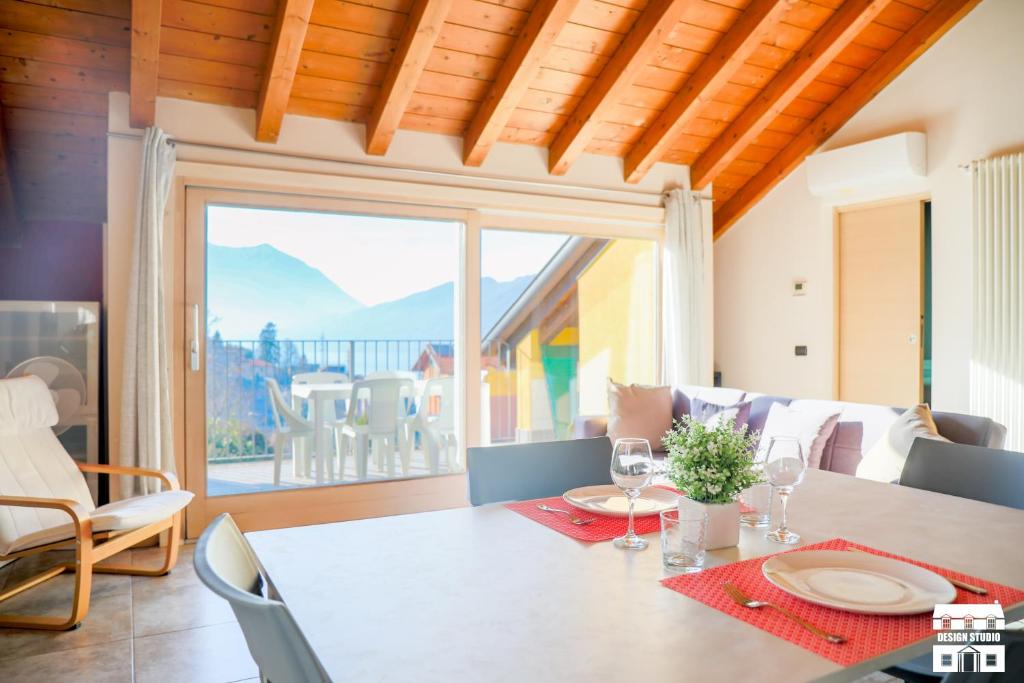 ein Esszimmer mit einem Tisch und einem großen Fenster in der Unterkunft COLOMBERA by Design Studio in Bellano