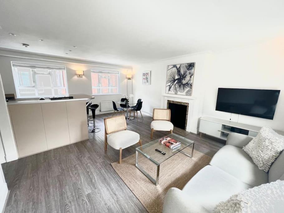 uma sala de estar com um sofá e uma mesa em Mayfair - Split Level 2 Bed Apartment em Londres