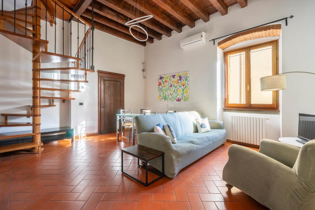 uma sala de estar com um sofá e uma escada em Ginori 29 double em Florença