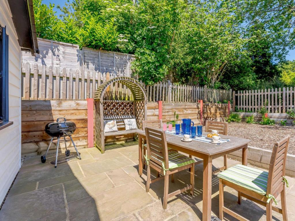 a patio with a table and chairs and a grill at 2 bed in Three Oaks 83438 in Fairlight