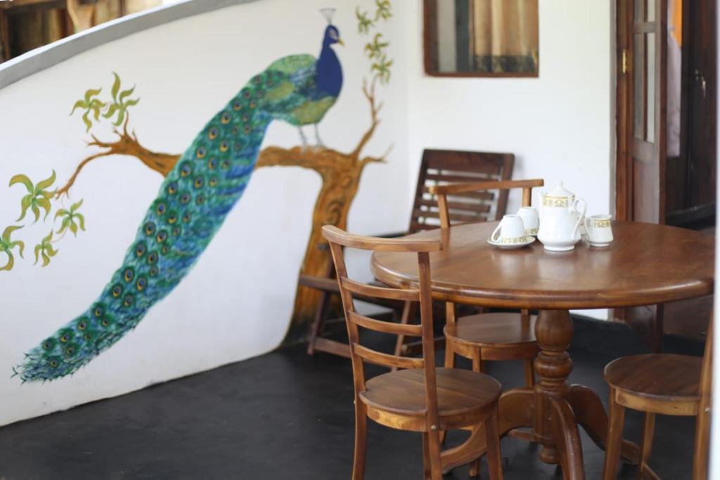 a dining room with a peacock painted on the wall at Mirissa Jungle view in Mirissa