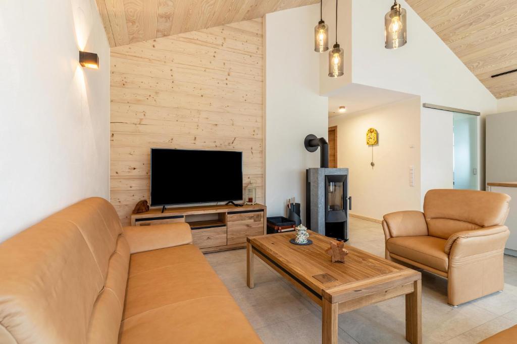 ein Wohnzimmer mit einem Sofa und einem TV in der Unterkunft Im Rosengarten 3 in Zell am Harmersbach