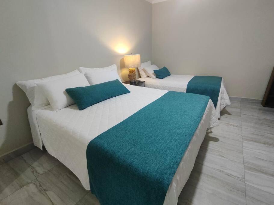 2 Betten in einem Hotelzimmer mit in der Unterkunft Alojamiento-frente al estadio 4 personas in Tarija