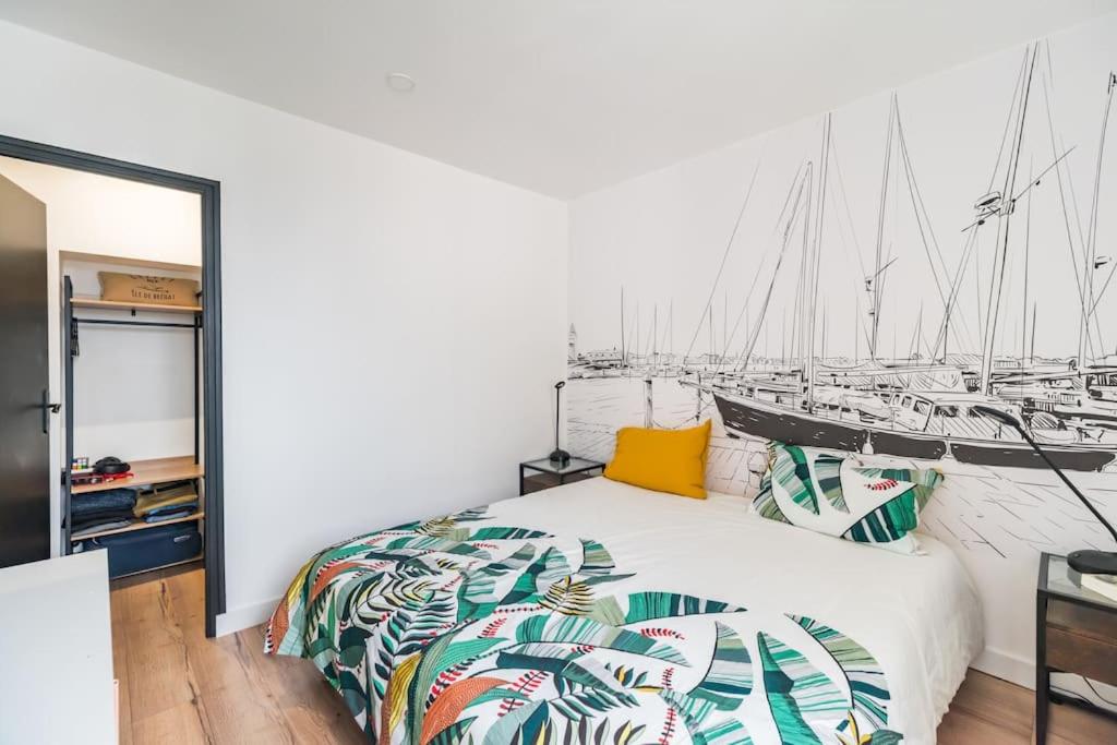 a bedroom with a bed with a mural of boats at L&#39;Escale Paimpolaise 2 Étoiles - centre historique in Paimpol