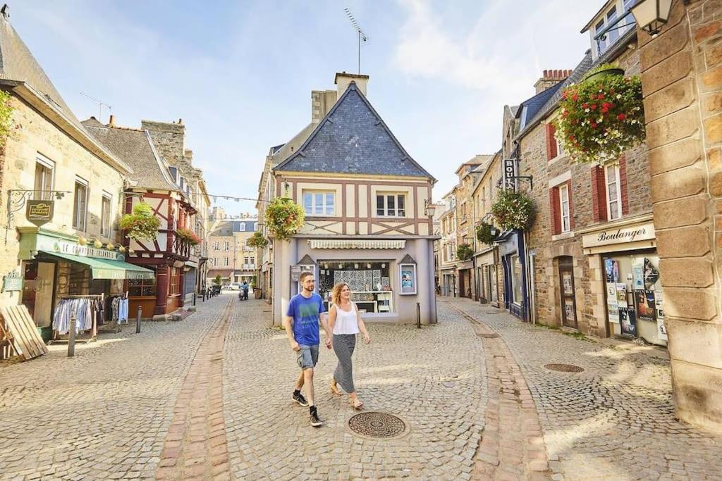 a man and a woman walking down a street at L&#39;Escale Paimpolaise 2 Étoiles - centre historique in Paimpol