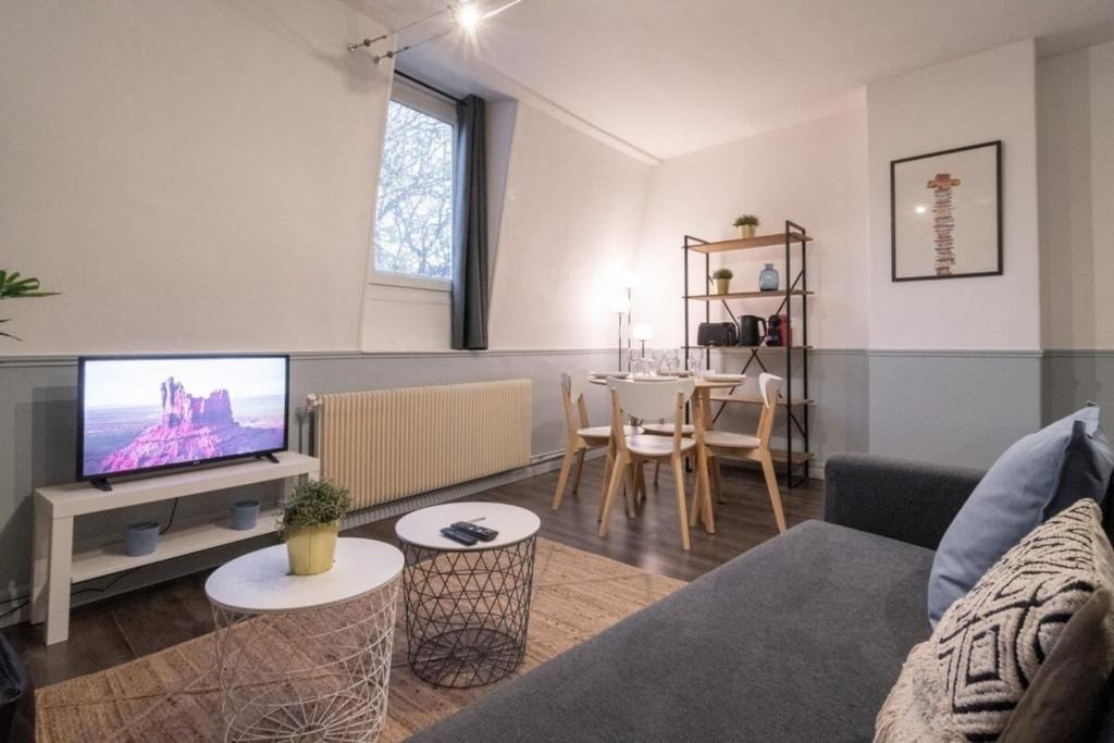 - un salon avec un canapé, une télévision et une table dans l'établissement Apartment near the train station ouigo TGV, à Tourcoing