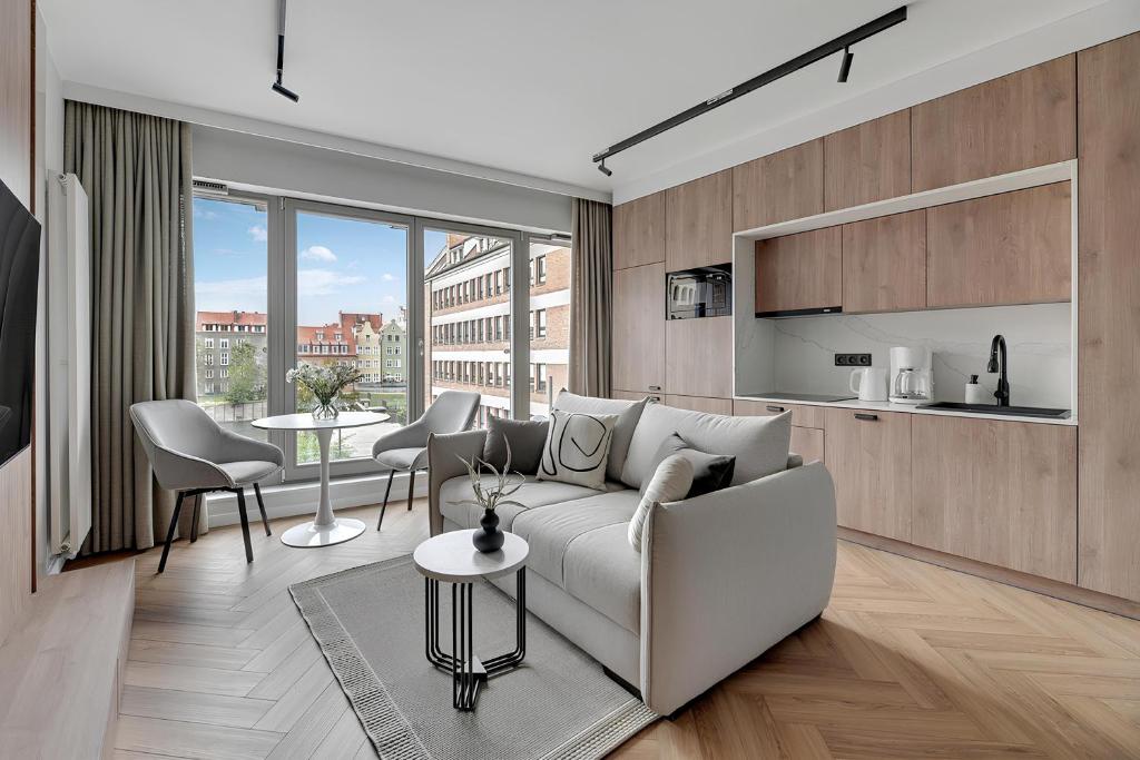 sala de estar con sofá y mesa en Flatbook - City Center SPA Apartments Grano Residence with Riverview & Parking en Gdansk