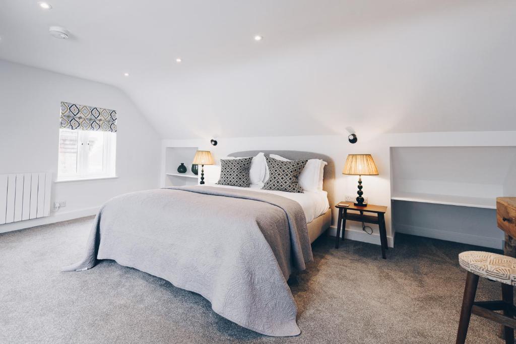 a white bedroom with a bed and two lamps at South Street Apartments in Chichester