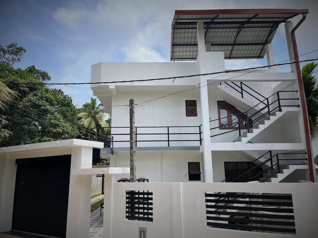 a white house with a staircase on the side of it at Samarathunga Guest House in Katunayake