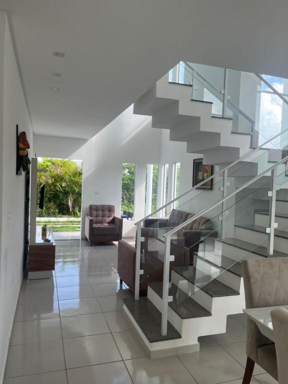 a glass staircase in a living room with a couch at Condomínio Villa Verde Triunfo in Triunfo