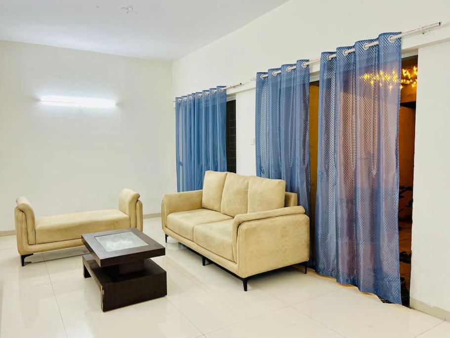 a living room with a couch and a table at 2BHK Oasis in Prime Kharadi in Pune