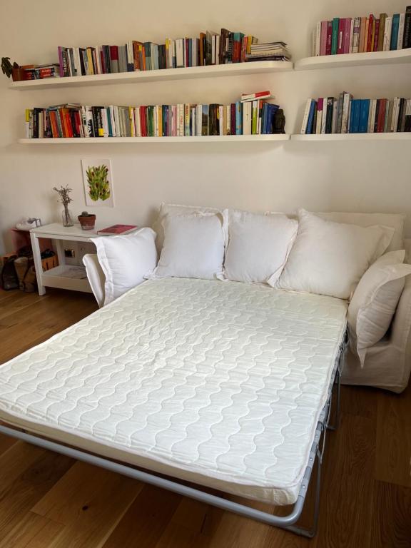 a bed in a room with a couch and books at Bloom as you are in Bologna