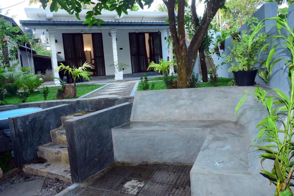 a stone bench in front of a house at Lake & Ocean Villa ahangama in Elagawagoda