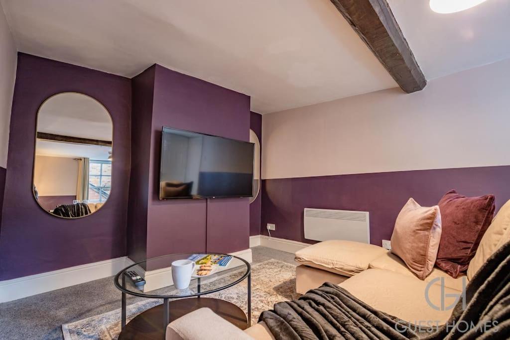 - un salon avec un canapé et un miroir dans l'établissement Guest Homes - Chandan Court Apartment, à Bewdley