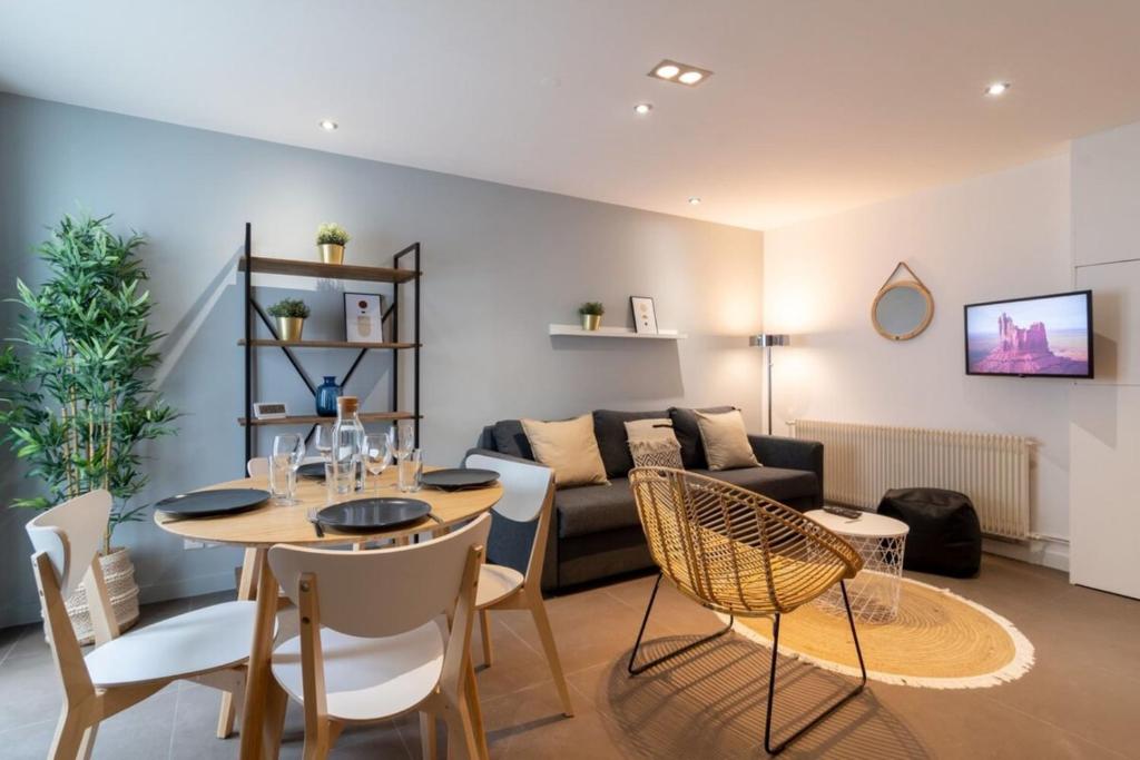 ein Wohnzimmer mit einem Tisch und einem Sofa in der Unterkunft Tourcoing equipped apartment with terrace in Tourcoing