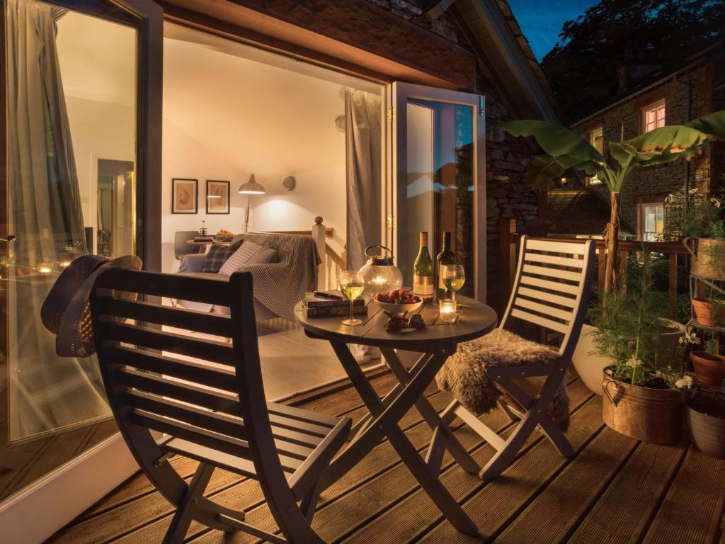 un patio con una mesa y 2 sillas en un porche en 1 Bed in Coniston LCC37 en High Nibthwaite