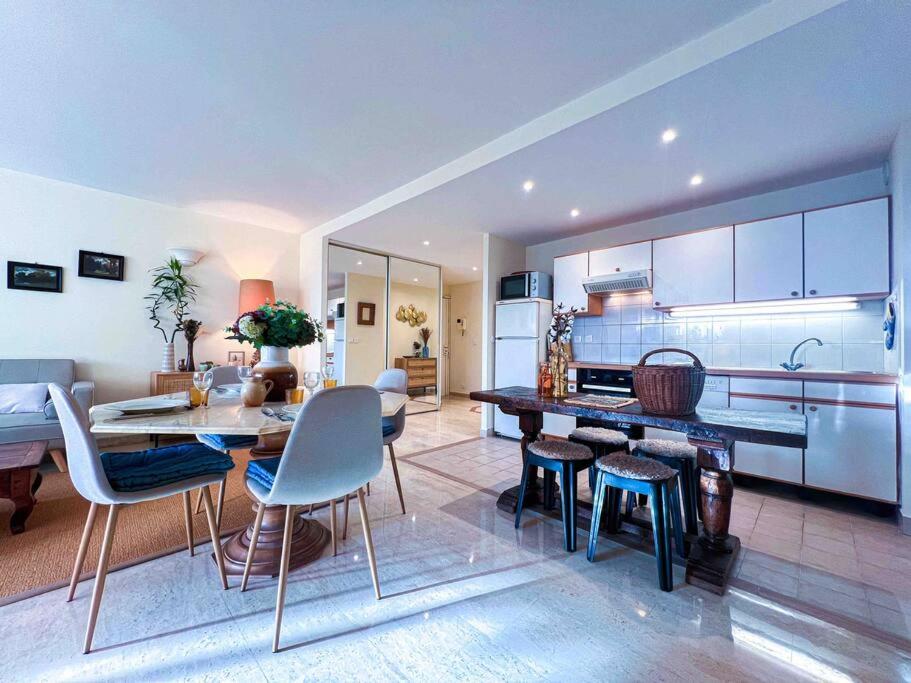 een keuken en een woonkamer met een tafel en stoelen bij New ! Terrasse Vue Mer - A 10min de Cannes in Le Cannet