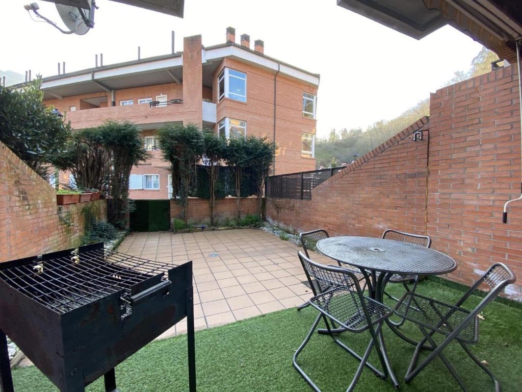 a backyard with a grill and a table and chairs at Casa La Dulce Olaya a pocos minutos de Oviedo 